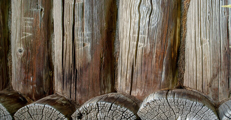 Fototapeta na wymiar texture of an old wooden house. Coniferous log house. Under the rising sun, wind and frost. a lot of time. the tree turned black from the weather. texture. background. template