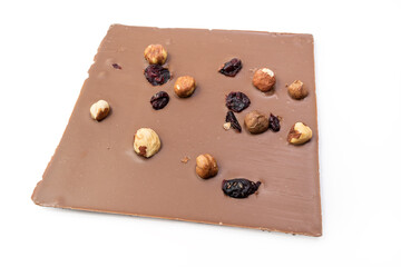 Hand crafted milk chocolate with hazelnuts, raisins and dried fruits on white background. Clipping path included
