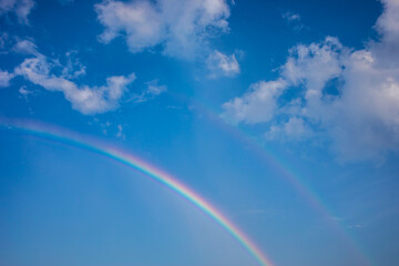 Beautiful rainbow with blue sky and clouds.