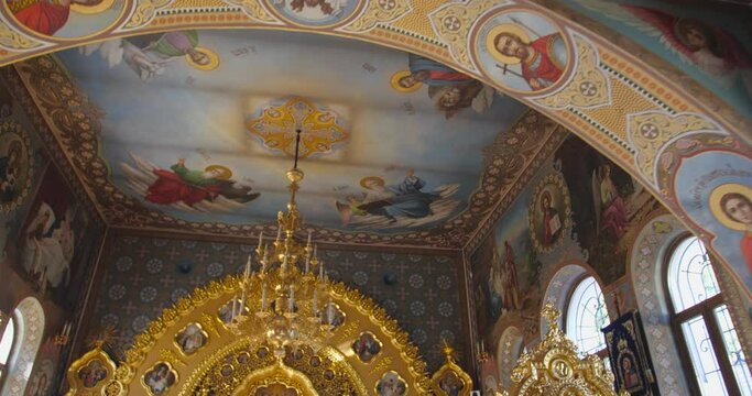 KYIV, UKRAINE � OCTOBER, 02, 2021 Kiev Pechersk Lavra Beautiful interior view incide  Christian Orthodox church. Tracking shot, golden altar and  chandelier on the ceiling.
