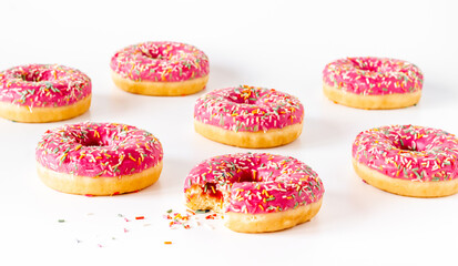 Group of pink frosted donuts with colorful sprinkles