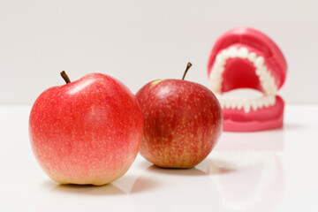 Apples and layout of the human jaw on background.