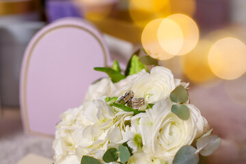 wedding bouquet of flowers, 
wedding rings on a bouquet 