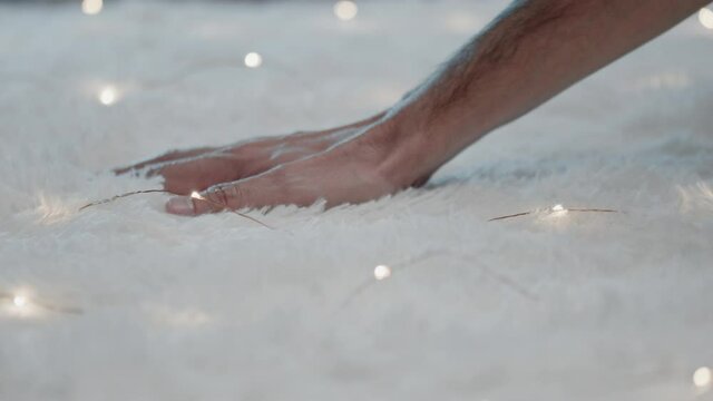 Mano accarezza un tappeto bianco con striscia di luci led