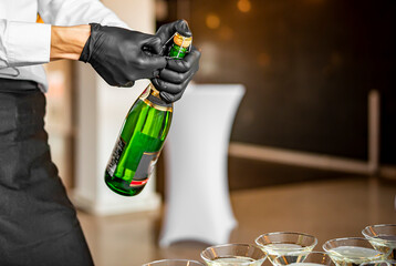waiter hand open champagne wine bottle