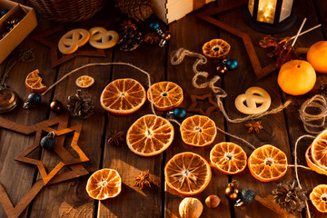 Dried slices of oranges cut into circles lie on a wooden table. New Year's Flatley