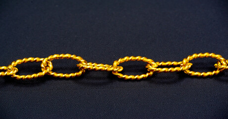 Fototapeta na wymiar Gold chain to be worn around the neck. A chain is a sequential assembly of connected parts, made of gold, with an overall character similar to that of rope in that it is flexible and curved
