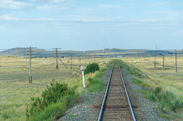 Fototapeta na wymiar railway, railroad, rail, elevated. steppe prairie veld. is a means of transportation and passengers of trucks moving on rails that are located on the rails of the Great Plains. Kazakhstan 