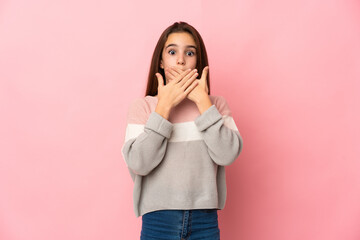 Little girl isolated on pink background covering mouth with hands