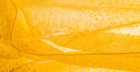 yellow silk textile fabric. Its properties differ from woven fabric in that it is more flexible and lighter in design. texture, background