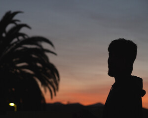 Atardecer tranquilo con contraste  con palmera y montaña