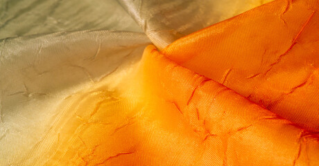 Silk fabric Orange yellow. Gradient of fabric colors. Dented and smoothed with traces of stripes....