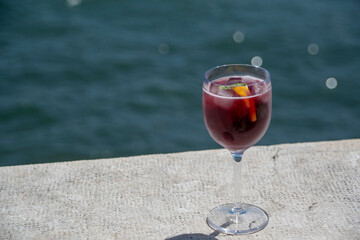 Landscape of glass of sangria on a ledge near water in summer in Lisbon Portugal