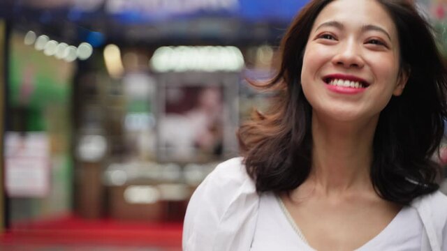 Slow motion of cheerful happy pretty young asian woman walking in the urban city street lovely young people in the city