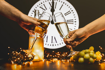 Couple toast to the new year with two glasses of champagne. Celebrating New Year's Eve. Lucky...