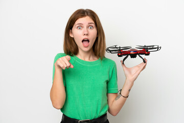 Young English woman holding a drone isolated on white background surprised and pointing front