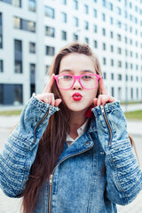 young pretty brunette business woman posing emotional against modern building in glasses holding coffee, lifestyle people concept