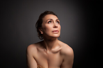 Fototapeta na wymiar portrait of a sensual fifty year old woman on grey studio background