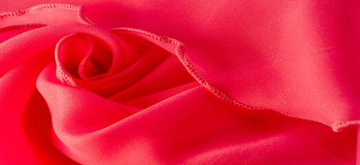 Red silk organza with wavy piping. Border around the edge of the fabric. Abstract background....