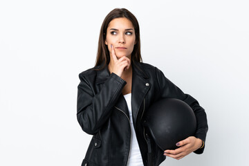 Caucasian girl holding a motorcycle helmet on white background thinking an idea