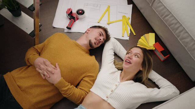 Young couple smiling confident lying on the floor at new home