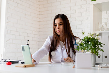 Young doctor or scientist woman using microscope, having online call showing samples, teaching online