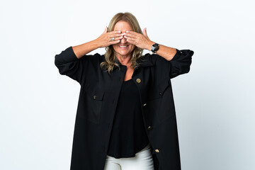 Middle aged blonde woman over isolated white background covering eyes by hands and smiling