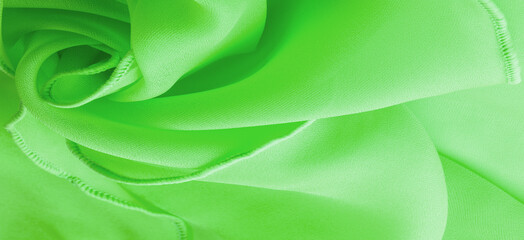 Green silk organza with wavy piping. Border around the edge of the fabric. Abstract background....