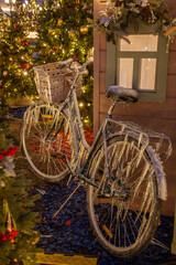 Fototapeta na wymiar Ice-covered bicycle near cristmas fir-tree and picturesque wooden house in winter Moscow, Russia