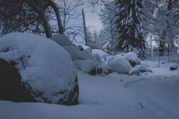 snow covered big granite boulders near country road