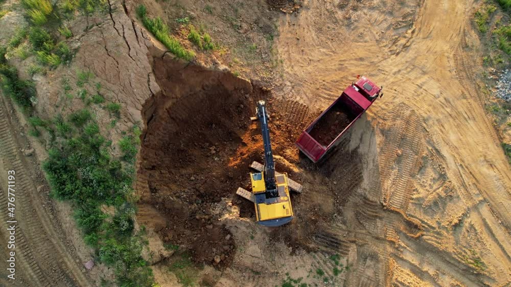 Poster excavator load the sand into dump truck. aerial view of an backhoe on earthworks. open pit developme