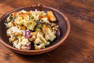 Baked vegetables with pumpkin with cheese in a plate, close-up, copy space