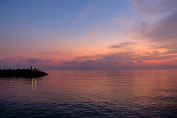 View on the pier at the amazing pink sunset on the sea.