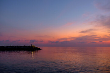 Naklejka premium View on the pier at the amazing pink sunset on the sea.