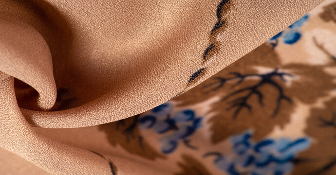 Silk Crepe de Chin. The color is beige, the flowers are blue. It is a group of silk characterized by roughness and also slightly wrinkled. Texture