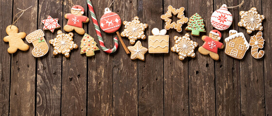 Christmas cookies, gingerbread Santa Claus man, wishing sock biscuit, snow flake shaped ginger cookie placed on rustic wooden background, happy holidays