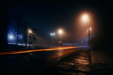 Fog at night in the city, late autumn, on the background of the road