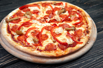 Hot tasty traditional italian pizza with salami, cheese, tomatoes greens