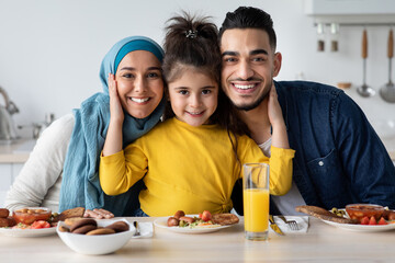 Portrait Of Happy Modern Islamic Family With Little Daughter Having Breakfast Together