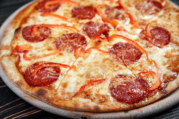 Hot pizza with Pepperoni Sausage on a dark background