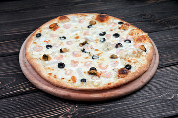 Seafood Italian pizza with shrimp,squid, mussels, fresh herbs and mozzarella