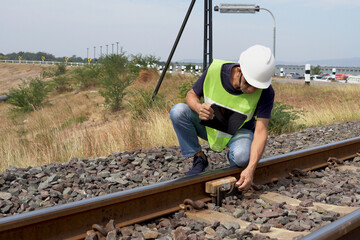Asian male engineer inspecting, report of railway inspection results with tablet.