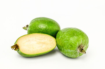 A feijoa and cut in half on a white background