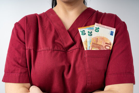 Nurse in burgundy colored hospital uniform with euro banknotes in the pocket