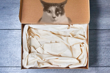 There is a box with a white cloth for a pet with a picture of a cat..