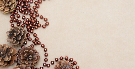 New Year card. Cones and brown beads on a parchment background. Craft paper. Abstract image.