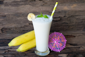 Banana fresh cocktail vanilla smoothies  fruit juice beverage healthy the taste yummy in glass drink episode good morning on wooden background.