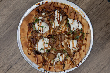 Overhead view of fancy roasted bosc pear pizza with panchetta in the perfect personal sized pan for a single meal