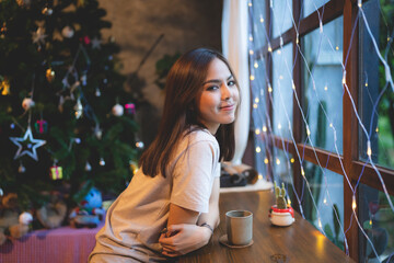 young Asian woman are happy and enjoy to celebrate for Christmas eve in cafe, Christmas party light background showing in coffee cafe