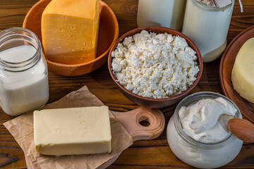 Dairy products. Bottles with milk, cheese, sour cream, butter on a wooden background
